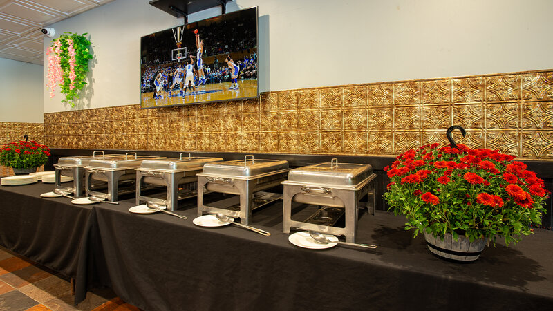 Chafing dishes at buffet table with flowers